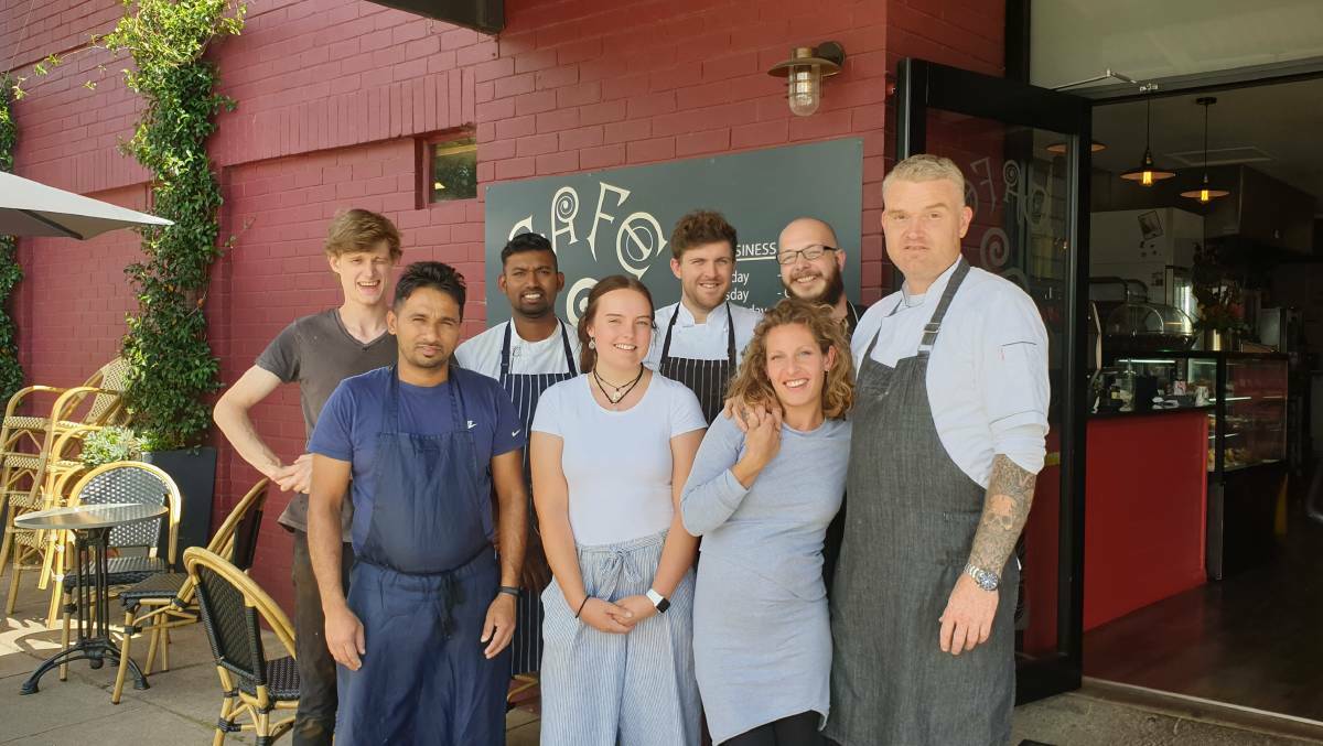 Nathan wearing the dark grey apron alongside his wife Enora, with staff outside the Café Patisserie on Rusden Street in Armidale. Picture: supplied