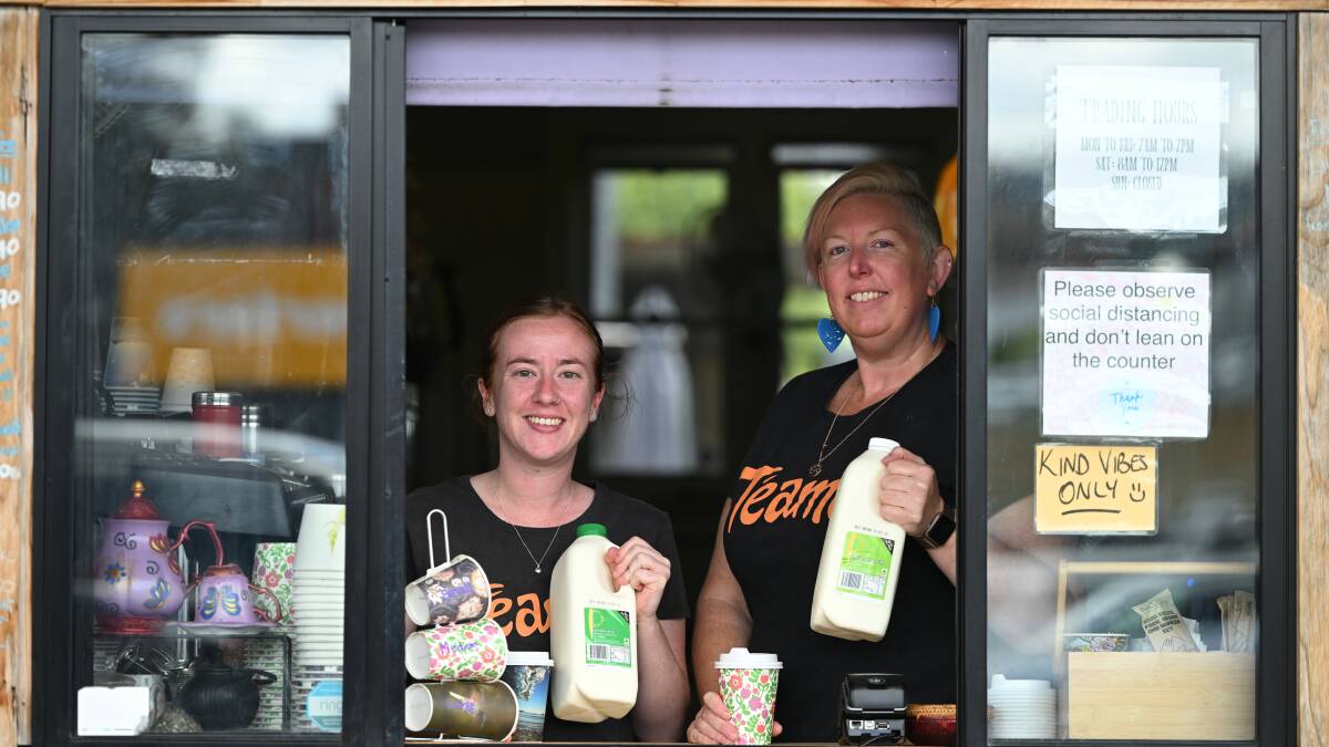 Teamo cafe staff Emily Castles and Prue Ross stand at their cafe window holding the liquid gold of their coffee, Peel Valley Milk. Photo by Gareth Gardner