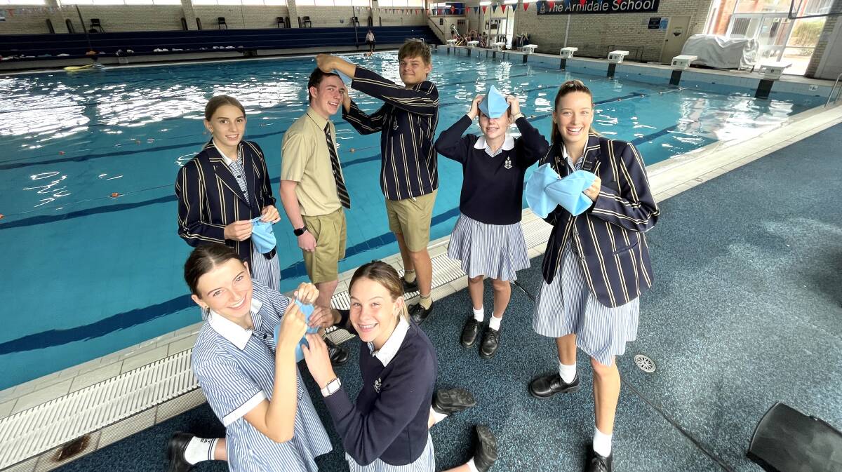 Eryn Benham, Tom Crowley, Will Glover, Reegan Jackson, Sofia Paris, (front) Maddy Nicholls and Alice Bourne get ready to wear blue caps to promote positive mental health in the Coffs Coast Ocean Swim. Picture supplied