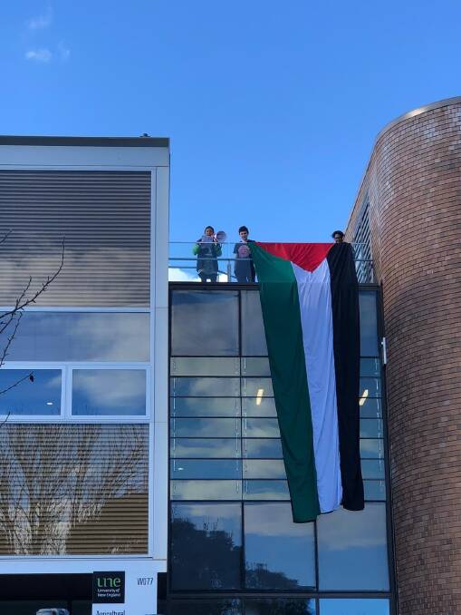 A six-metre Palestine flag is unfurled by protestors at the University of New England in Armidale on Sunday, May 26. Picture supplied. 