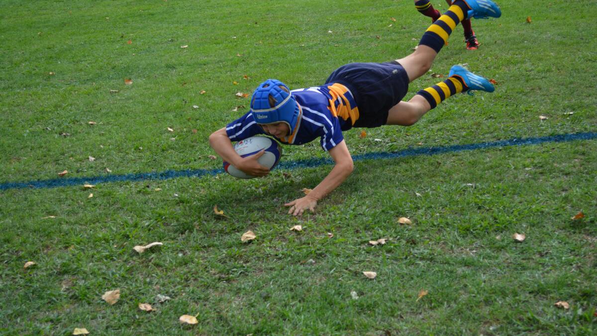 TAKING CHARGE: St Marys’ Darcy Booth leaps over the try-line untouched to score at last year’s TAS Rugby Carnival.